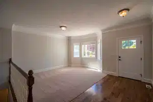 Entrance foyer featuring crown molding, a textured ceiling, baseboards, and wood finished floors