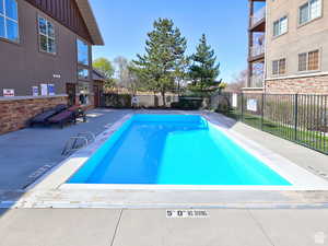 Community pool featuring fence and a patio