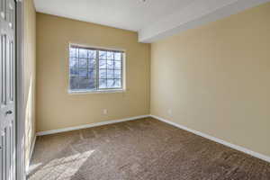 Carpeted empty room featuring baseboards