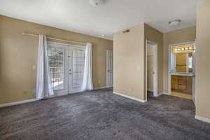 Unfurnished bedroom with carpet flooring, visible vents, baseboards, access to outside, and french doors