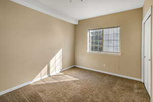 Carpeted empty room with beamed ceiling and baseboards