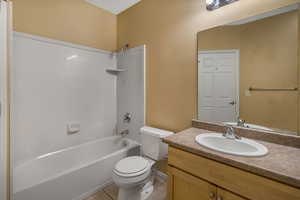 Bathroom featuring tile patterned flooring, tub / shower combination, vanity, and toilet