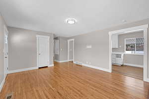 Interior space with light wood-style floors, baseboards, and visible vents