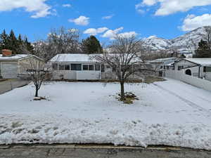 View of front of house with a sunroom, fence, a mountain view, and a detached garage