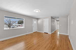 Entrance foyer with visible vents, light wood-style flooring, and baseboards