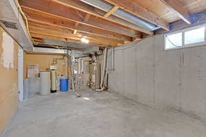 Below grade area with water heater, visible vents, and heating unit