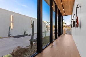 Hall featuring visible vents, wooden ceiling, wood finished floors, floor to ceiling windows, and track lighting