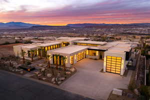 View of front of home with a garage, concrete driveway, a mountain view, and stucco siding