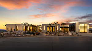 View of front facade featuring driveway, a garage, and stucco siding