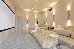 Home theater room with recessed lighting and light carpet