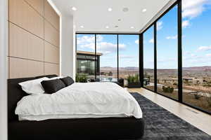 Bedroom with visible vents, light wood-style flooring, a wall of windows, a mountain view, and recessed lighting