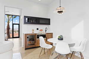 Dining room featuring light wood-style floors and wet bar