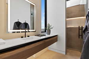 Bathroom with tiled shower, tile patterned flooring, and vanity