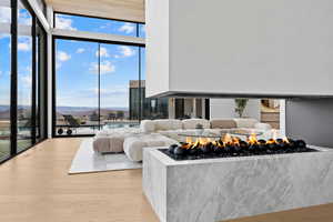 Living area with expansive windows, light wood finished floors, and a mountain view