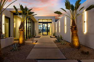 Exterior entry at dusk featuring stucco siding