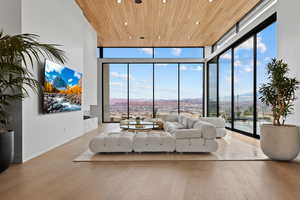 Living area featuring a wall of windows, recessed lighting, wood ceiling, and wood finished floors