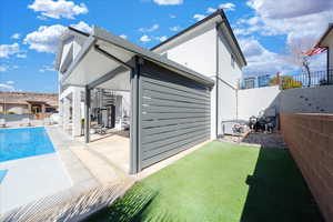 Back of property with a patio, a fenced backyard, and a fenced in pool