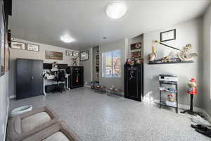 Office space featuring visible vents, baseboards, a textured ceiling, and speckled floor