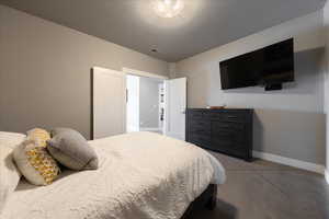 Bedroom featuring visible vents, a textured ceiling, and baseboards