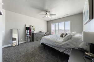 Carpeted bedroom featuring visible vents, ceiling fan, and baseboards