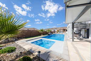 View of pool featuring an in ground hot tub, a patio, a fenced backyard, and a fenced in pool