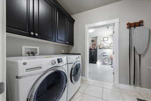 Clothes washing area with cabinet space, baseboards, and separate washer and dryer