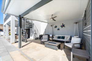 View of patio / terrace featuring a ceiling fan, an outdoor living space with a fire pit, and stairs