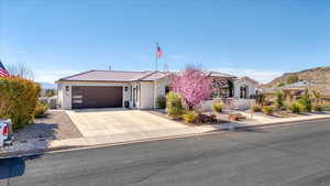 View of front facade featuring driveway, stucco siding, a garage, and a tiled roof