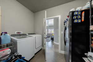 Clothes washing area with laundry area, baseboards, and separate washer and dryer