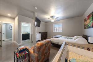 Bedroom with concrete flooring, a textured ceiling, and baseboards