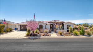 Mediterranean / spanish house with a fenced front yard, an attached garage, a tile roof, driveway, and stucco siding