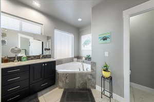 Full bathroom with a bath, tile patterned flooring, vanity, and baseboards