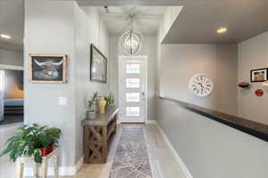 Foyer entrance with a chandelier, recessed lighting, and baseboards