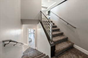 Stairway with tile patterned flooring and baseboards