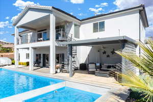 Back of house with stairs, a patio area, an outdoor living space, and stucco siding