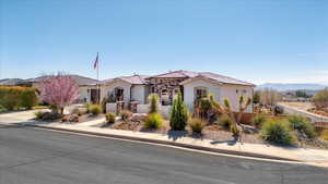 Mediterranean / spanish-style house featuring a fenced front yard, a mountain view, a tiled roof, and stucco siding