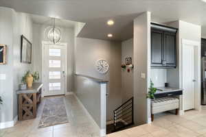 Foyer entrance featuring marble finish floor, baseboards, a notable chandelier, and recessed lighting