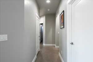 Hallway featuring finished concrete flooring and baseboards