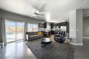 Living area with recessed lighting, visible vents, ceiling fan, a textured ceiling, and baseboards