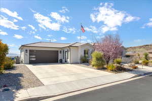 View of front of property with a garage, concrete driveway, a tile roof, and stucco siding