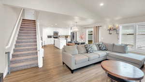 Living room with lofted ceiling and light hardwood / wood-style flooring