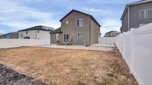 Rear view of house with a patio and a lawn