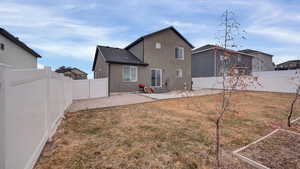 Back of property with a yard and a patio area