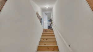 Stairs featuring a textured ceiling