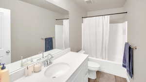 Full bathroom with hardwood / wood-style floors, shower / bath combo, vanity, and toilet