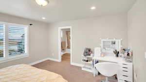 Carpeted bedroom featuring multiple windows