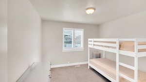 Bedroom featuring light carpet