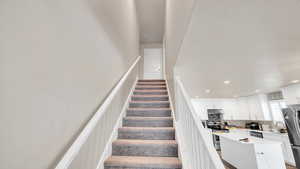 Stairs with sink and a textured ceiling