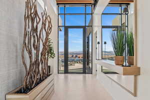 Doorway to outside featuring expansive windows, a mountain view, and tile patterned floors