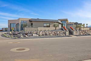 View of front of house with stairs and stucco siding